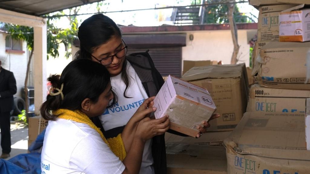 Aarati Poudel, national UN Volunteer Specialist, Cold Chain Specialist and Reshu Kuskusmia (right), national UN Volunteer Specialist, Health Data and Information Technician with UNICEF Nepal check information on the vaccines’ box ahead of their field work. 