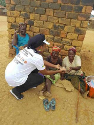 UN Volunteer Michèle Diane Karambiri raises awareness among the elderly of the importance of the census, while helping them with household chores in the village of Minga, during the pilot enumeration of the fifth general population and housing census of Congo.