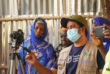 Gopi Kharel (Bhoutan), Volontaire des Nations Unies spécialiste de la communication auprès de la FAO en Gambie, enregistrant la vidéo d’un bénéficiaire pour transmettre des histoires de réussite pour le plaidoyer et la communication.