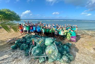 Participants in a UNICEF campaign in Kiribati for the International Day for Biological Diversity, together with the mounds of plastic waste they collected.