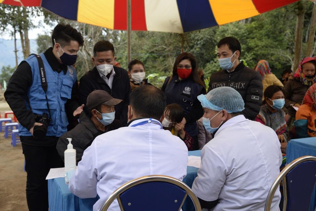 Minh Pham (far left in blue gilet) and other WHO officers with local health personnel observing a COVID-19 vaccination site in Nan Ma commune, Xin Man district – Ha Giang province. December 2021. ©️WHO Viet Nam