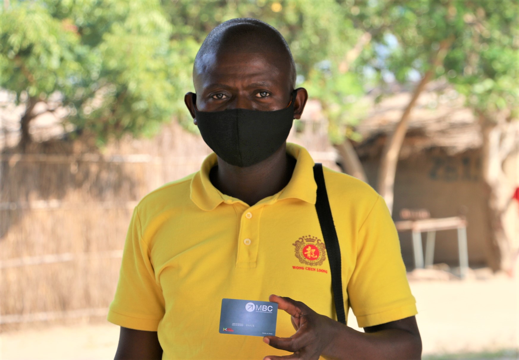 Refugee holding his first bank card as a symbol of financial inclusion in Maratane settlement, Nampula. 
