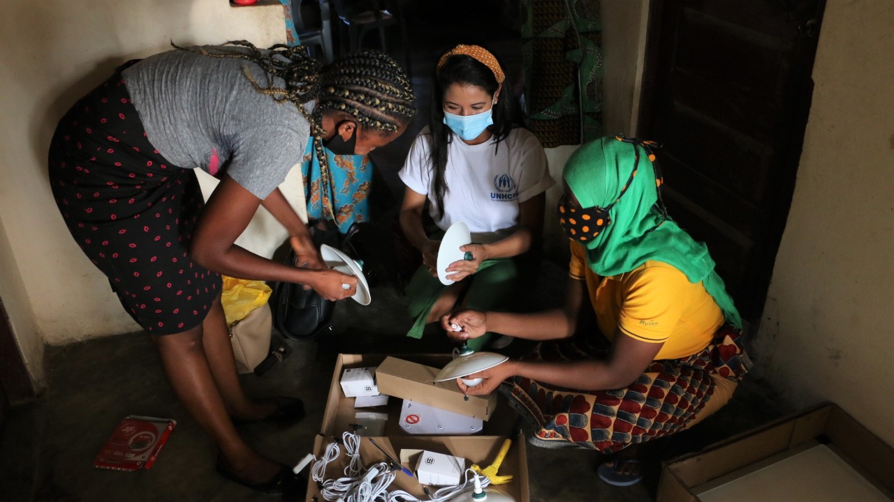 UNHCR staff supporting internally-displaced women who participated in training to install and operate solar-powered sewing machines and lamps in Nacala, Nampula Province.