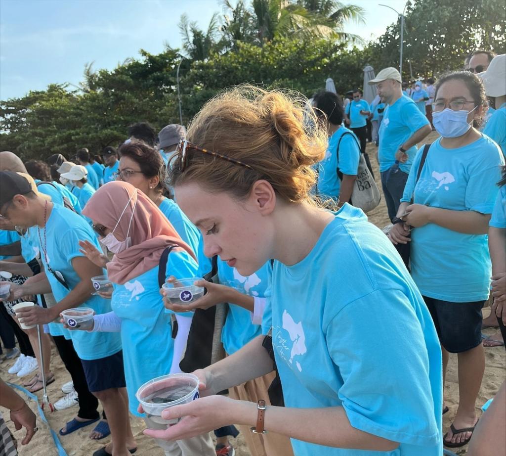 Helene Ries, International UN Volunteer with World Bank Indonesia during a turtle release to the sea with the World Bank staff