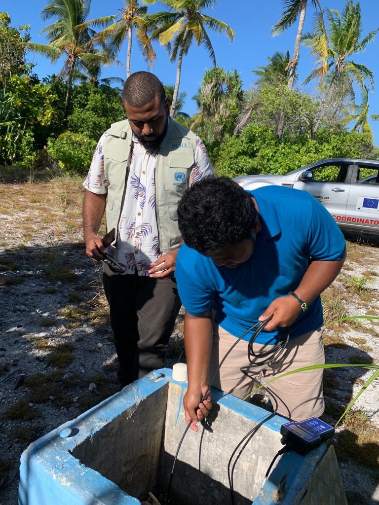 Lepani Penijamini Vunituraga (left), national UN Volunteer, Humanitarian Officer with OCHA Pacific inspects the testing of the Bonriki Water Reserve during the drought response, ©️ OCHA Pacific, 2022