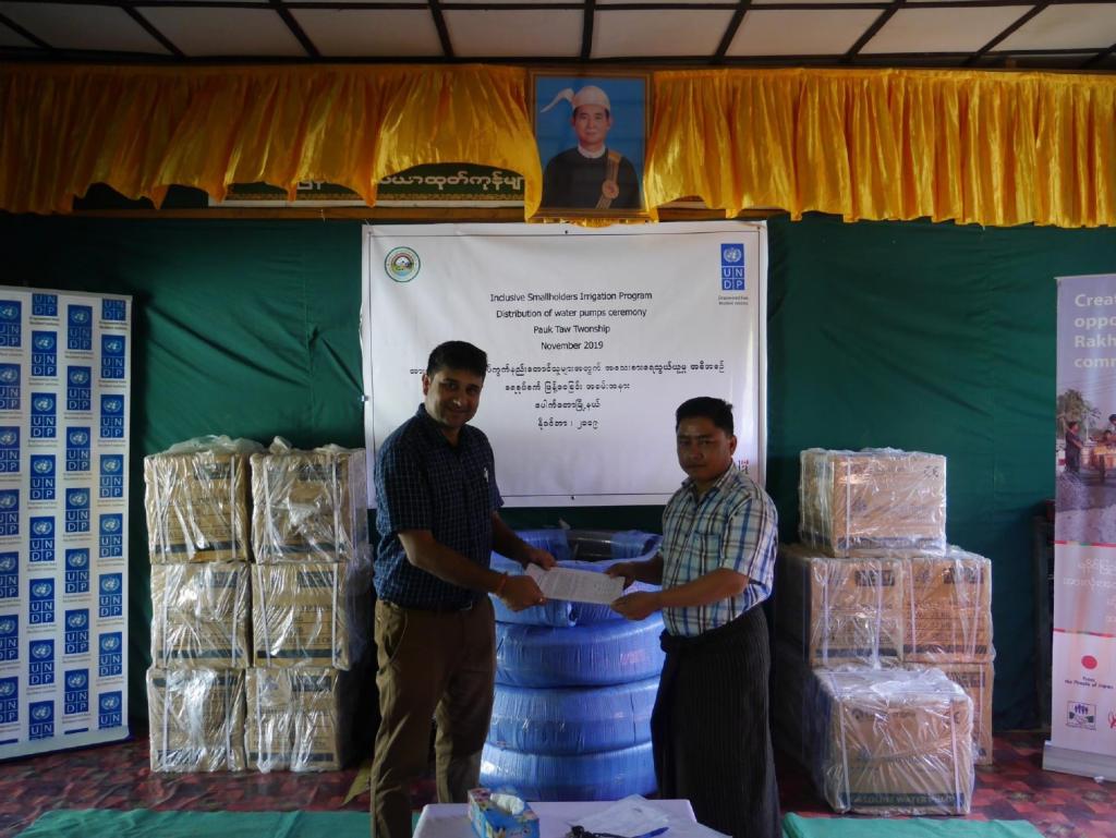 2.	Prabesh Paudyal (left) International UN Volunteer Specialist with UNDP Myanmar during a handover of water pumps to the government representative in Rakhine State, Pyaing Taung village, Pauktaw Township - ©️UNDP Myanmar