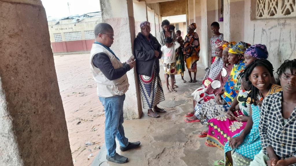 UN Volunteer Ramos Cassimo during an awareness-raising exercise for the population at the Carreira de Tiro reception center in the Mocuba municipal area. He delivered key information on harassment prevention, emergency hotlines and cholera preventive measures.