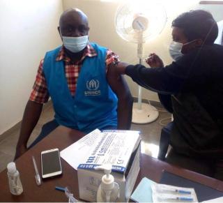 Wycliffe Matende, Public Health & Nutrition Associate receiving Covid19 vaccination, to protect himself and others.