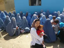 Atsuko Hirakawa in front of the Independent Election Commission in Parwan, where Afghan women wait to receive a Voter’s ID card to vote in the Presidential and Provincial Council elections.