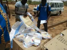 UN Volunteer Ferdinand Koanari (right) inspects electoral supplies delivered for the elections in Sebba, Burkina Faso.