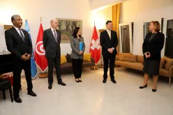 A group of people standing in a room with flags