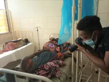 Joelma Pereira (right) international UN Volunteer Communications Officer in a field mission in Moma district, Nampula province in Mozambique takes photos of survivors of the cyclone Gombe in March 2022.