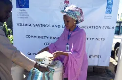 Raihana Bello Furo, Volontaire Communautaire avec le PNUD dans la communauté de Guyaku (Nord-Est du Nigeria) pendant l'activité de responsabilité sociale de l'entreprise conformément à la VSLA.