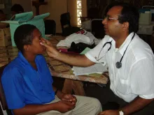Former international UN Volunteer Doctor from India, Dr. Mukeshkumar Prajapati, photographed here while conducting a medical evaluation on an adolescent in Trinidad and Tobago in 2005.