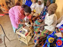 Elodie Toe, UN Volunteer Midwife with UNFPA, collects a blood sample for prenatal testing at the Salla Health Centre.