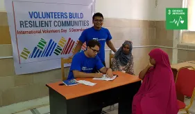 On International Volunteer Day, Jainarayan Singh (seated, India), UN Volunteer Medical Doctor with UNDP, offers refugees a health check-up at Hargeisa Group hospital, Somalia.