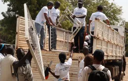 Gideon Sackitey (right) helps colleagues to offload mattresses - part of the items they donated to the children's ward at Bor Town Hospital  in South Sudan - from a truck.