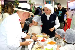 WFP official and a chef teaching children about healthy food choices.