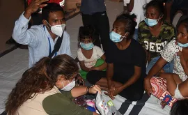 UN Volunteers Silverio Correia (with raised hand) and Katya Castillo (in khaki vest) engage internally displaced persons at Balide catholic parish hall in Dili, one of the temporary evacuation centers for flood victims in Timor-Leste.