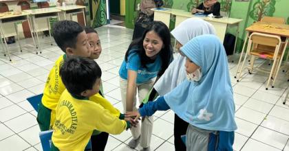 Isna Aulia Fajarini (centre), national UN Volunteer Nutrition Officer with UNICEF, interacts with elementary school children in Jakarta.