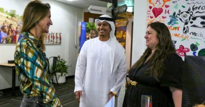 Three people engage in discussion at an office.