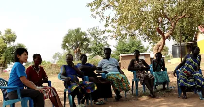 Kei Tanaka, UN Volunteer with UNHCR, meets rice farmers at a refugee settlement in Uganda. 