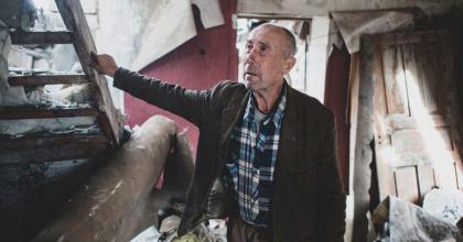 An older man showing the house he had built for his children that was largely destroyed due to active hostilities in Zhovanka village, Donetska Oblast, Ukraine.