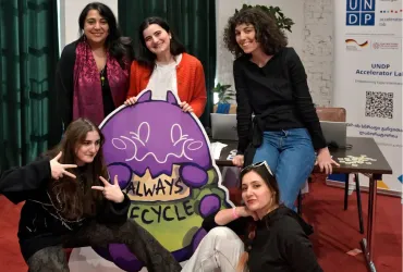 A group of smiling women holding a sign "Always Recycle"