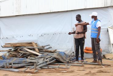 UN Volunteer Jonathan Biaback (right), who serves with WFP in Cameroon, supervises the set-up of a food distribution site in Minawao camp. 