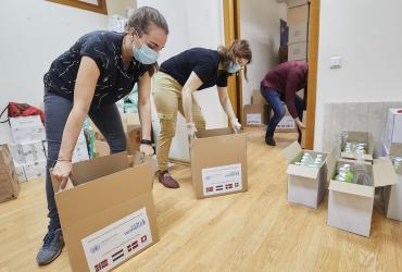 UN Youth Volunteer Florence Homberger helps pack boxes with Personal Protective Equipment (PPE) provided by UN Women for beneficiaries across Moldova in 2020.
