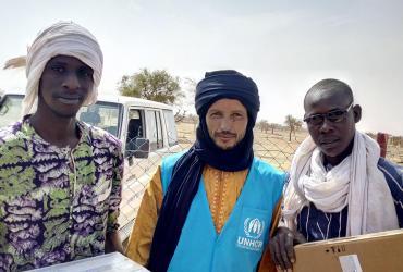 UN Volunteer UNHCR Oussamata Iba (centre), with two fellow refugees from the camp of Goudebou, Dori, Burkina Faso.