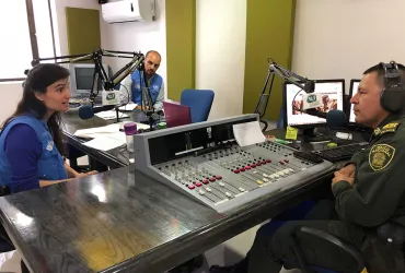 Marco Nardo, UN Volunteer Associate Protection Officer with UNHCR (centre), Vera Quina, Head of UNHCR Field Office of Mocoa (left) and Germain Bravo, Officer at the Putumayo National Police Department at the National Police Radio 93.2 FM, Mocoa, Colombia.