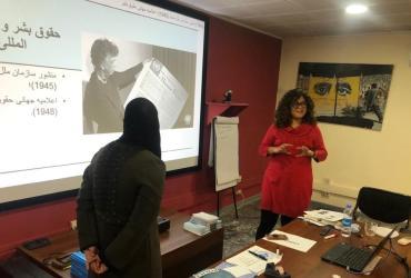 La Voluntaria de las Naciones Unidas Corina Elsa Rueda Borrero (de pie, de rojo) impartiendo un taller sobre normas de derechos humanos para mujeres afganas.