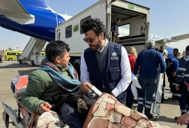 Ahmed Anas Awad, UN Volunteer, speaks to Palestinian patient being medically evacuated to Greece through the EU Civil Protection Mechanism.
