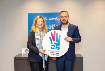 Louise Chamberlain, UNV Deputy Executive Coordinator, and Samed Ağırbaş, COP31 Climate High-Level Champion and President of the Zero Waste Foundation, hold the International Volunteer Day 2026 frame at UNV headquarters in Bonn.