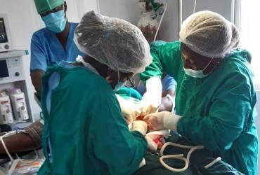 UN Volunteer Dr Sonia Bako (right) in action during surgery with her operating room team: Anaesthetist Cadidjatu Colubali (back) and Instrument Nurse Flamina Camala (left).