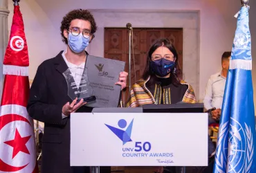 Aziz Zaguia, local volunteer with the Ministry of Public Health, receiving 'Tunisia Volunteer Award 2021' for his contributions to COVID-19 response.