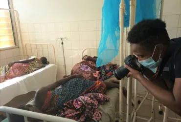 Joelma Pereira (right) international UN Volunteer Communications Officer in a field mission in Moma district, Nampula province in Mozambique takes photos of survivors of the cyclone Gombe in March 2022.