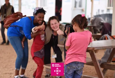 A Syrian girl taking a photo of UN Volunteer Anja Ingabire (right) at Zaatari Refugee camp, Jordan.