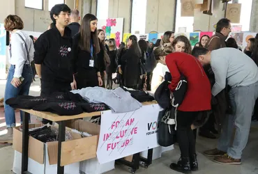 UN Youth Volunteer Minjoo Lee (left) with fellow volunteers at International Volunteer Day celebrations in 2019, welcoming participants to the exhibit and event. 