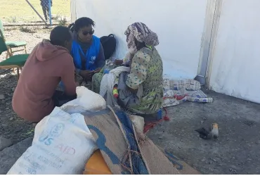 Lynn Karanja (in blue jacket), Associate Mental Health and Psychosocial Support Officer, UNHCR Ethiopia engages with a refugee woman in Alemwach Refugee Site to identify her needs and link her with the appropriate services. 