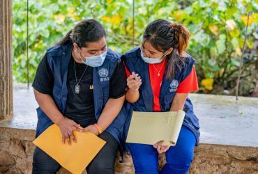Elina Resepwil (right) and Martha Asher are UN Youth Volunteers serving in community health engagement and communications. Here, they discuss the challenges of reaching children with immunizations in Pehleng, Kitti Community, on Pohnpei Island, Federated States of Micronesia.