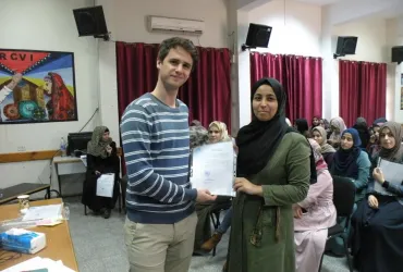 International UN Volunteer Mikael Maerker (fully funded by the Government of Sweden) handing out certificates at the end of a CV-writing workshop for UNRWA volunteers.