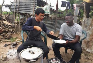 Volunteer Sompong Woragool (left), with the Friends from Thailand (FFt) Programme, learns how to make traditional food in Mozambique. 