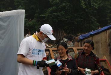 National UN Volunteer Gao Wei distributes food and medicine to local residents after Wenchuan Earthquake 