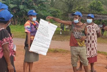Newly trained village health volunteer delivers public health information to community in North Fly District, Western Province.