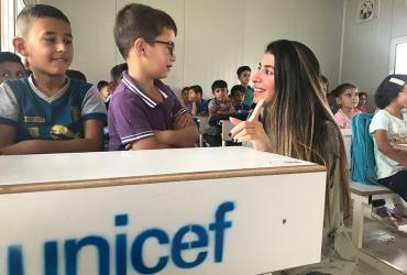 Rasha Abou Dargham with Syrian refugee children in a UNICEF-supported classroom in Baharka Camp, Iraq.