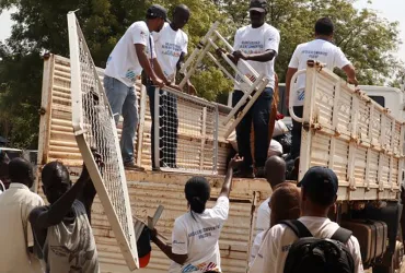 Gideon Sackitey (right) helps colleagues to offload mattresses - part of the items they donated to the children's ward at Bor Town Hospital  in South Sudan - from a truck.
