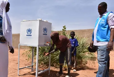 South Sudanese refugees washing their hands at a UNHCR facility during a registration exercise in South Darfur. Prior to the registration, UNHCR conducted a sensitization session about COVID-19, which included handwashing techniques.