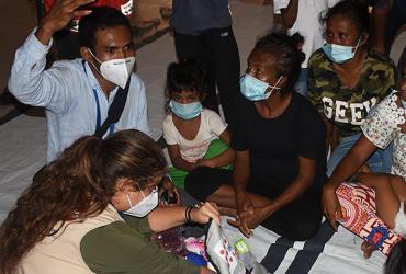 UN Volunteers Silverio Correia (with raised hand) and Katya Castillo (in khaki vest) engage internally displaced persons at Balide catholic parish hall in Dili, one of the temporary evacuation centers for flood victims in Timor-Leste.  